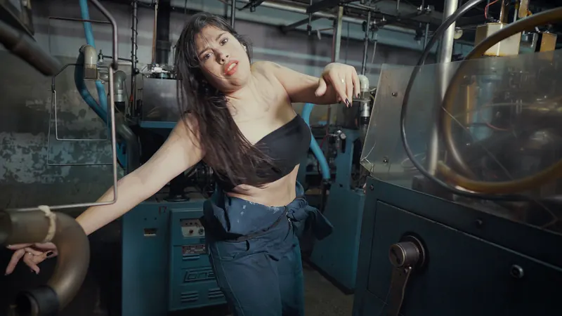 Una bailarina se mueve entre las máquinas de la fábrica.