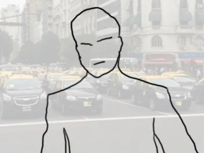 El hombre de frente, con la avenida detrás.